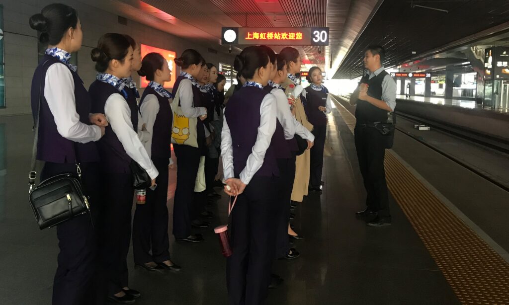 A picture showing David Feng training station crew in Shanghai on proper rail English terminology