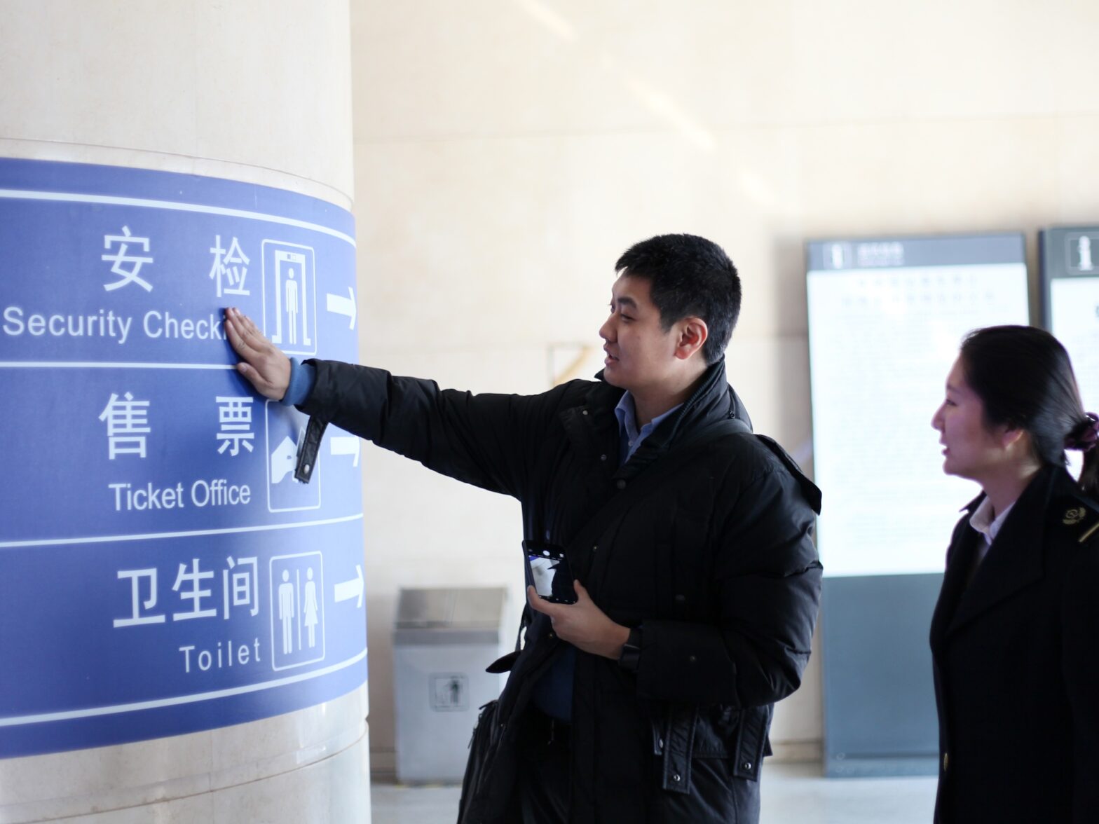 An image of David Feng checking railway English signage at Ji'nan West Railway Station
