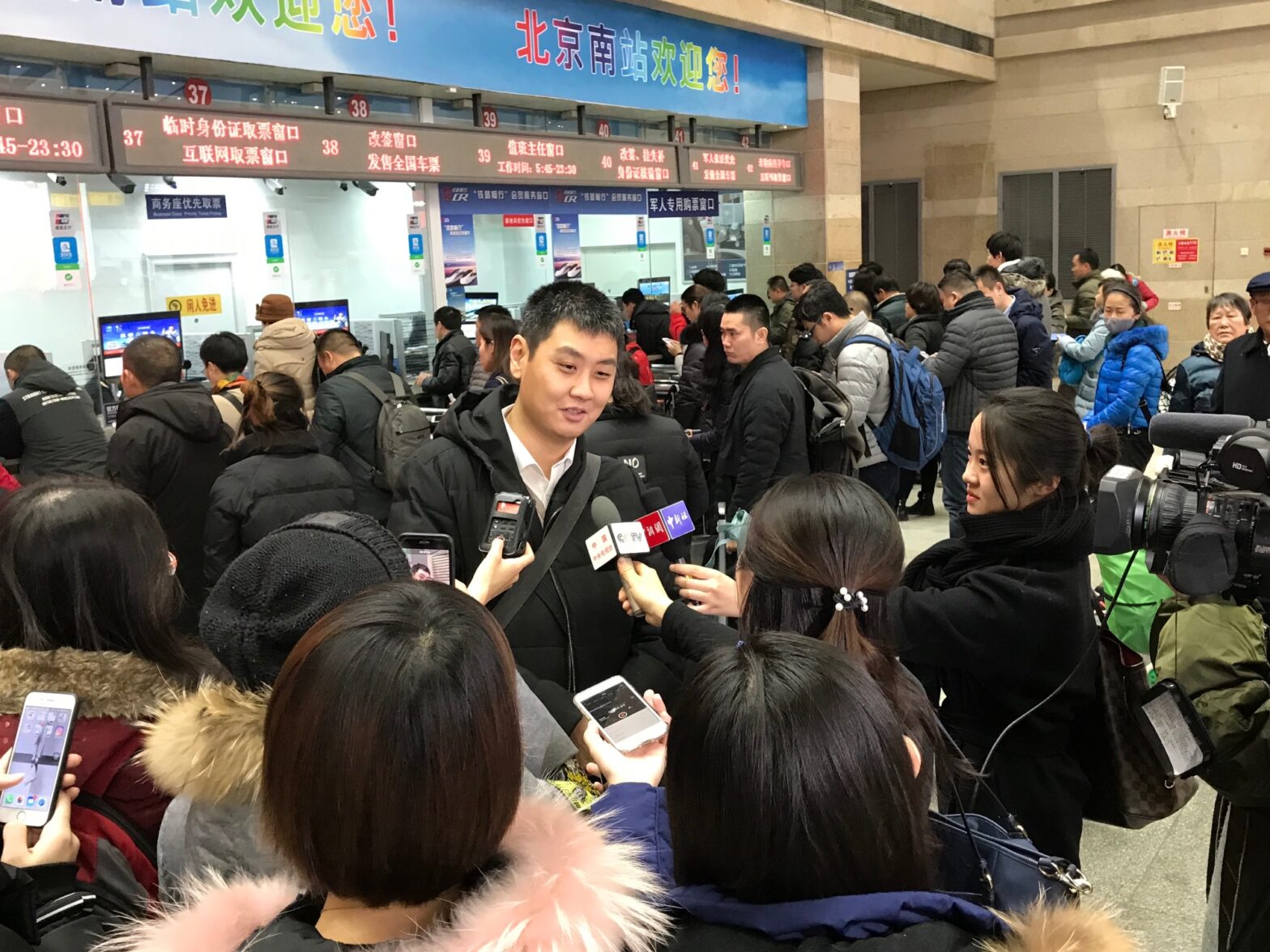 An image of David Feng being surrounded by members of the media