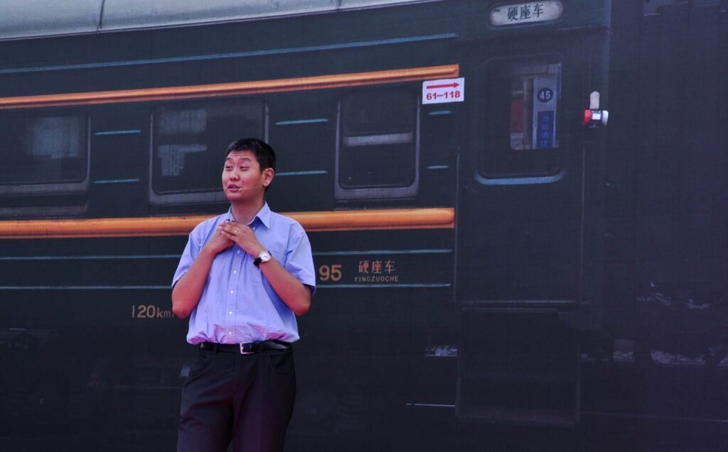 An image of David Feng in front of a China Railway Green Train (during a talk)