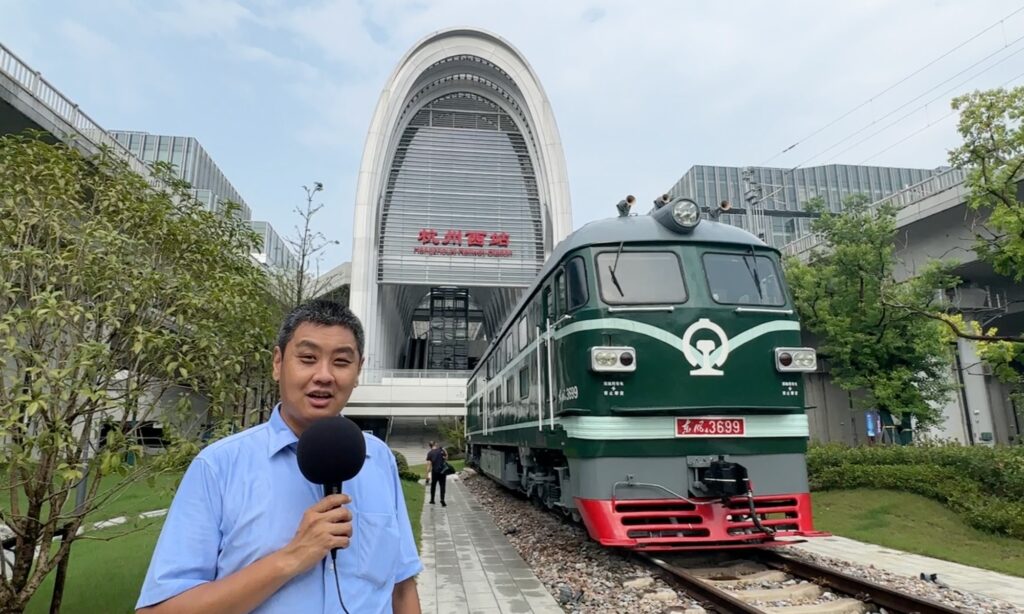 An image of David Feng presenting and filming at Hangzhou West Railway Station