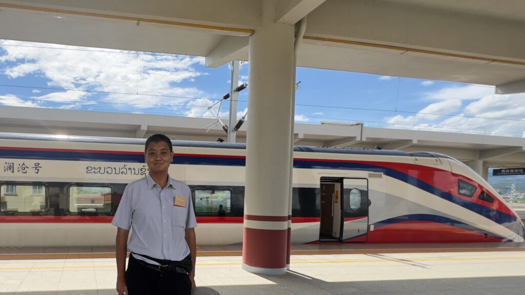 An image of David Feng next to a Lao LCR train at Sipsong Panna station, China