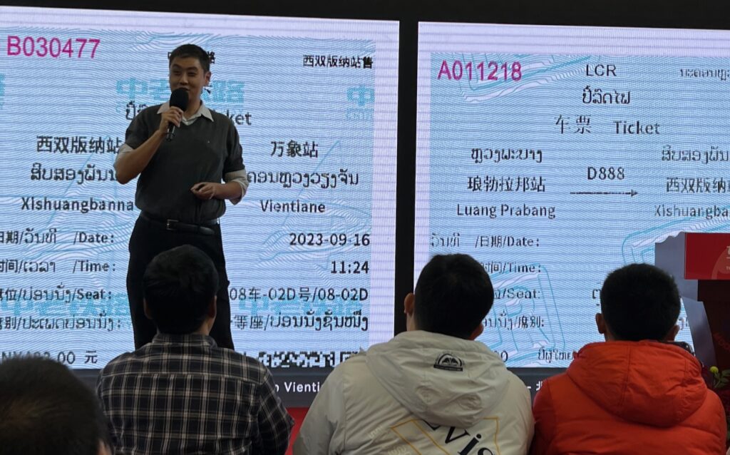 A picture of David Feng talking about tickets used on the China-Laos railway